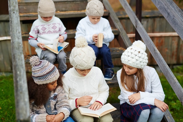 Children reading Books Outdoors