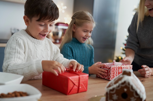 母親からクリスマスプレゼントを受け取る子供たち