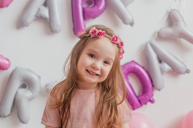 子供の誕生日 カメラの前でポーズをとってピンクのドレスでかわいい女の子の肖像画 プレミアム写真 子供の誕生日 カメラの前でポーズをとってピンクのドレスでかわいい女の子の肖像画 プレミアム写真