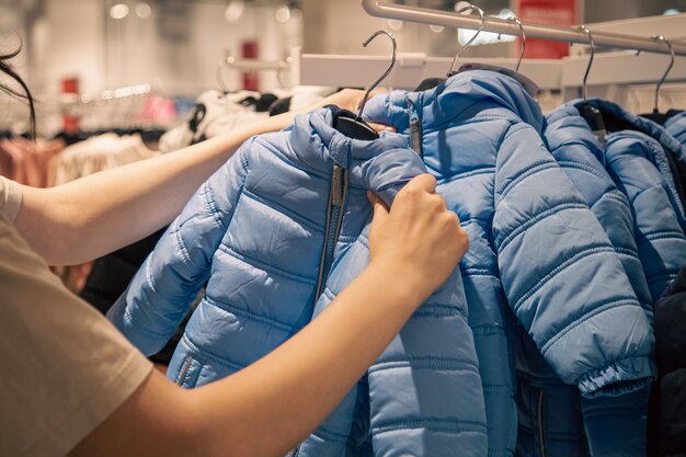 Детские куртки на вешалках в магазине одежды