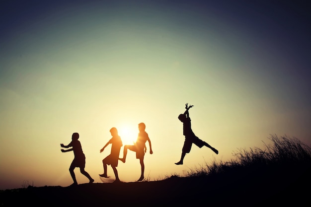 Children's silhouettes playing at sunset