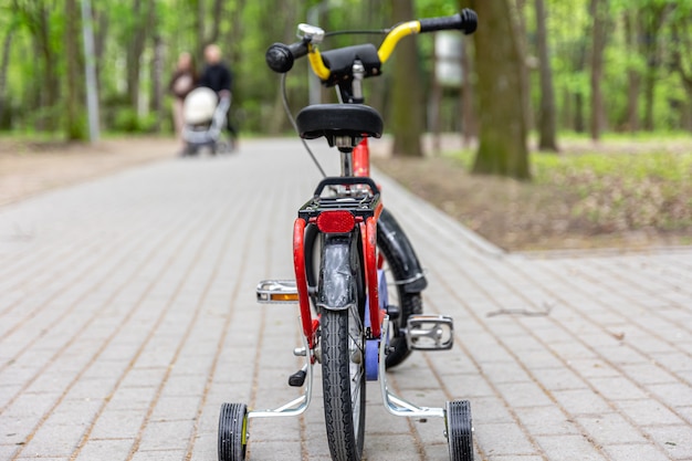 Детский трехколесный велосипед в парке на размытом фоне
