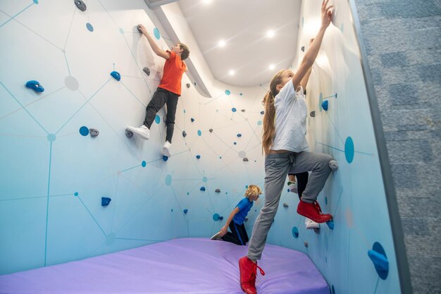 Children sideways to camera climbing wall