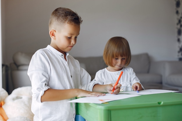 Children siting at the green table and drawing