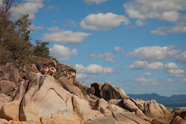 Children sitting on the big rocks at the beach