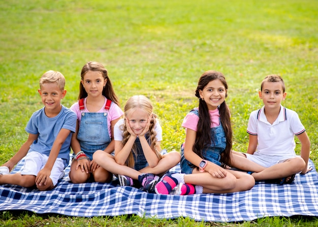 Children sitting on a blanket in the park