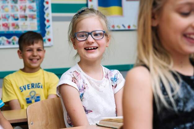 Children sitting in classroom smiling