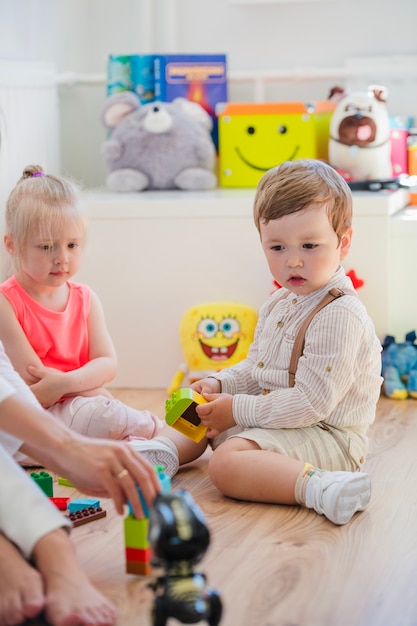 Bambini seduti in sala giochi sul pavimento