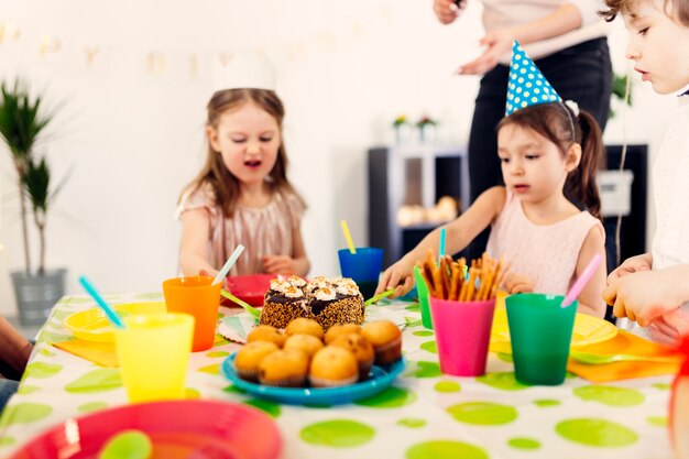 パーティーのテーブルに座っている子供たち