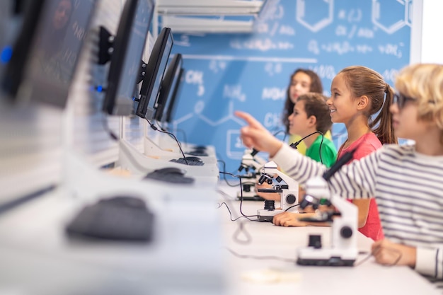 Children standing sideways to camera looking at charge boards