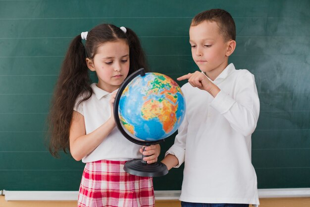 Children standing with globe