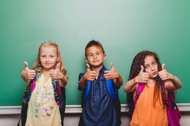 Children standing with thumbs up