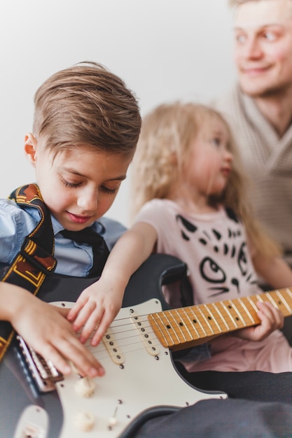 Foto gratuita bambini che toccano la chitarra di suo padre