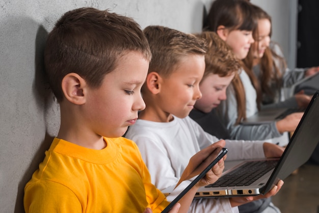Foto gratuita bambini che utilizzano dispositivi elettronici