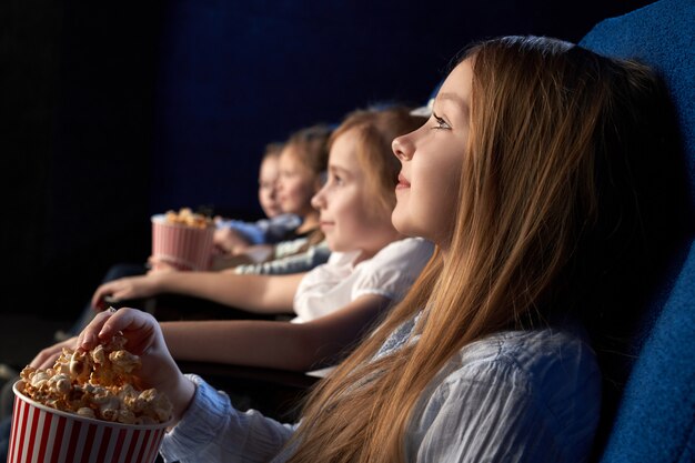 Children watching movie in cinema theatre.