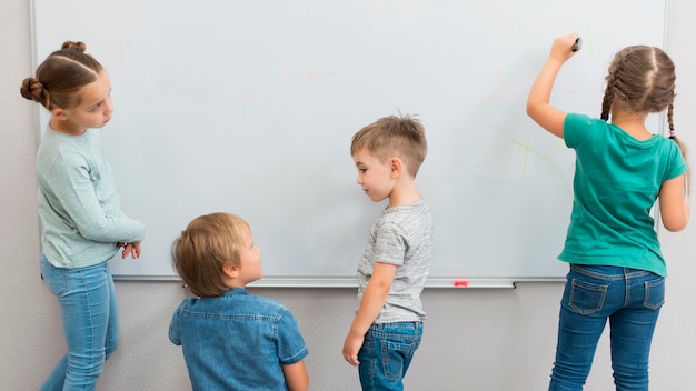 Children writing on a white board