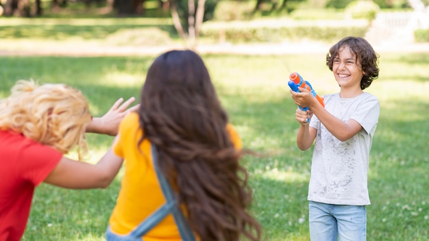 Бесплатное фото Дети играют с водяной пушкой
