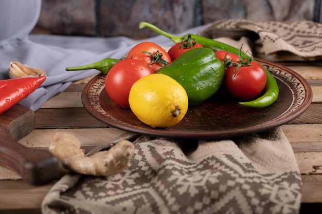 Chilies, tomato and lemon in a brown platter