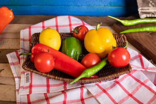 Chilies and tomatoes in a platter on the checked towel