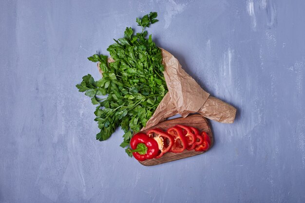 Chilies with herbs on blue