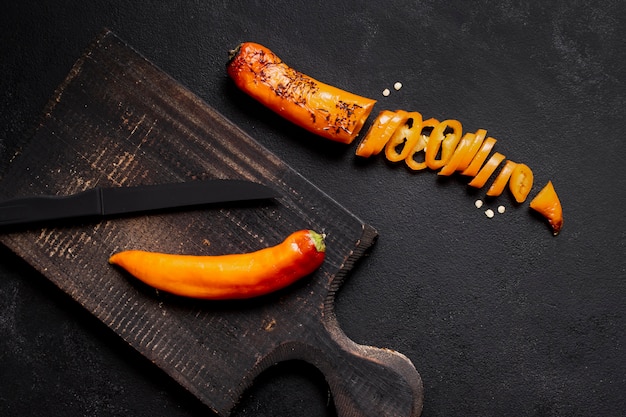 Chilli pepper sliced on wooden board top view