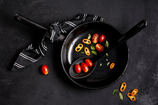 Перец чили и помидоры в черной сковороде