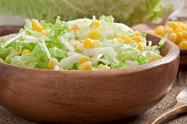 Chinese cabbage salad with sweet corn in a wooden bowl