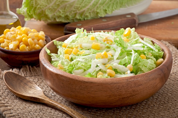 Free photo chinese cabbage salad with sweet corn in a wooden bowl