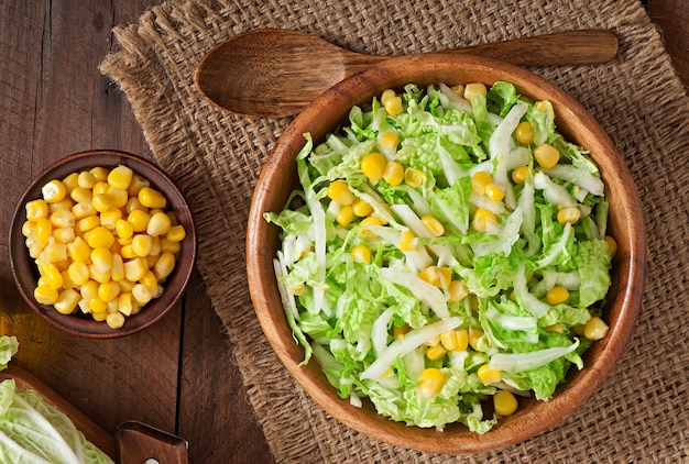 Chinese cabbage salad with sweet corn in a wooden bowl