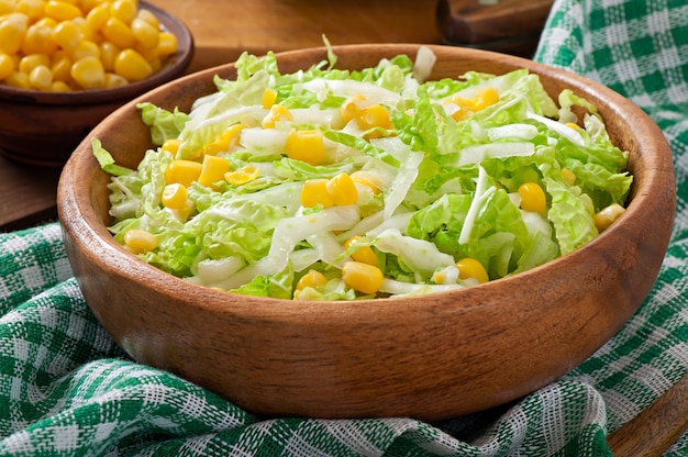 Chinese cabbage salad with sweet corn in a wooden bowl