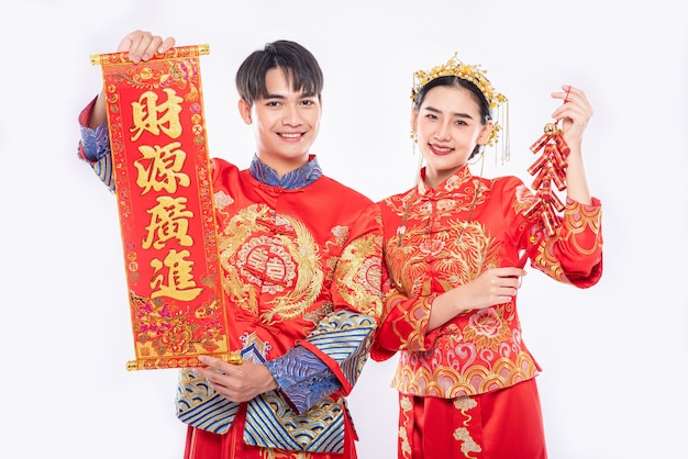Chinese greeting card and firecracker is used by man and woman wear Cheongsam suit to celebrate in chinese new year