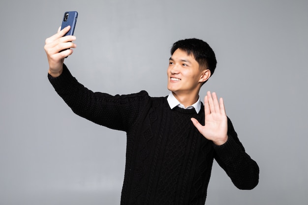 孤立した白い壁に、selfieを作る中国人男性