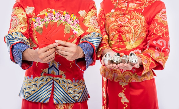 Foto gratuita il capodanno cinese riceverà denaro e denaro in regalo: da donare a uomini e donne che indossano il cheongsam tradizionale
