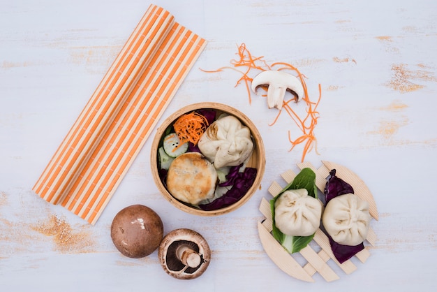 Chinese steamed dimsum in bamboo containers traditional cuisine on white wooden table