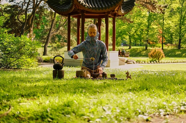 Foto gratuita cerimonia del tè cinese in un parco. bere il tè all'aria aperta.