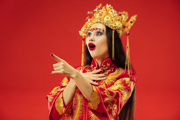 빨간색 배경 위에 스튜디오에서 중국 전통 우아한 여자.