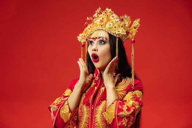 Free Photo chinese traditional graceful woman at studio over red wall