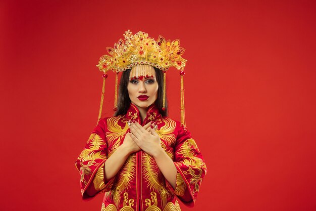 Chinese traditional graceful woman at studio over red wall