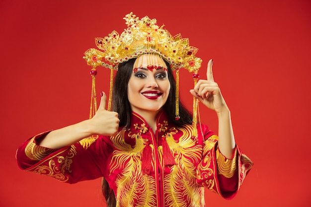 Chinese traditional graceful woman at studio over red wall