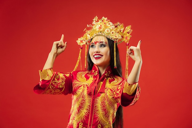 Free photo chinese traditional graceful woman at studio over red.