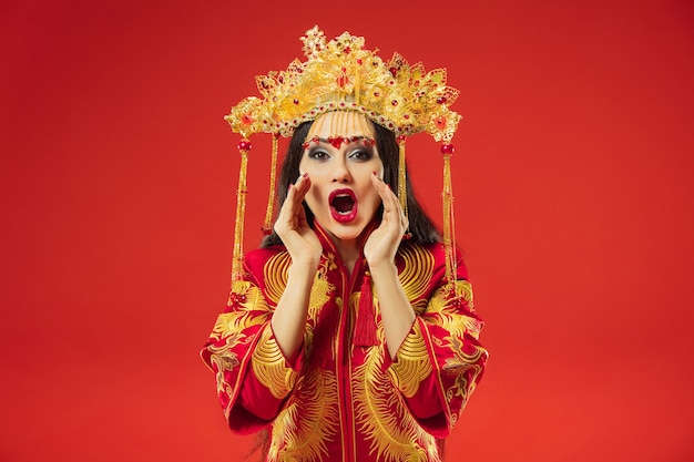 赤の上のスタジオで中国の伝統的な優雅な女性。