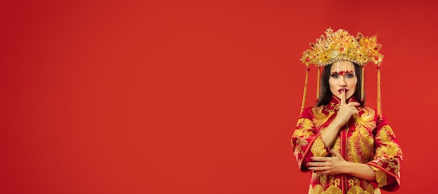 Free photo chinese traditional graceful woman at studio over red.