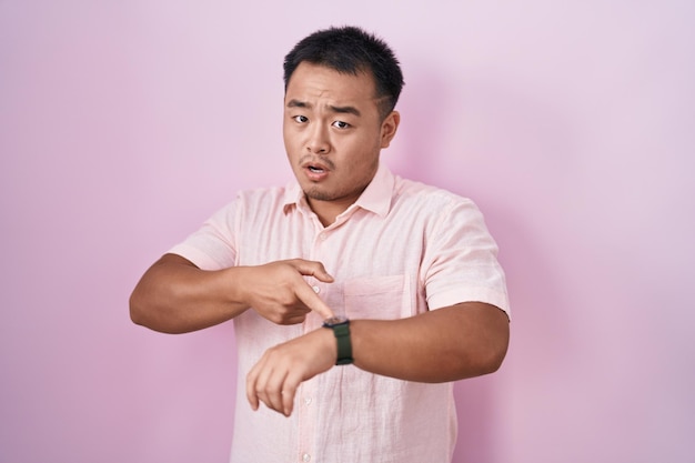 무료 사진 분홍 배경 위에 서 있는 중국 청년