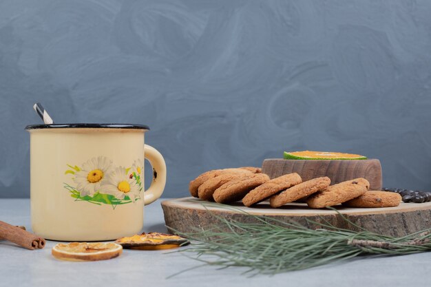 Chip cookies, cup of tea and slice of mandarin on gray background. High quality photo