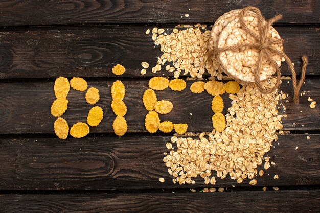 Chips and cereals salty spicy yummy diet word shaped along with tied bread biscuits on the brown wooden rustic floor