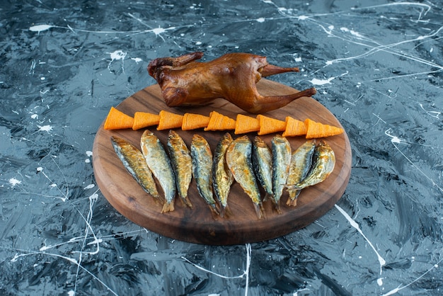 Foto gratuita patatine, pollo alla griglia e pesce su una tavola, sullo sfondo di marmo.