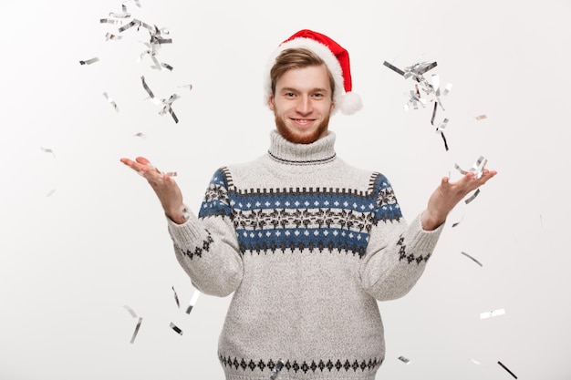 クリスマスの日を祝う紙吹雪を投げるChirstmasコンセプト幸せな若い白人のひげの男