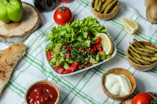 Choban salad with cucumber, tomato, greens and lettuce