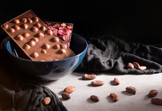 Chocolate bars in bowl and cocoa beans