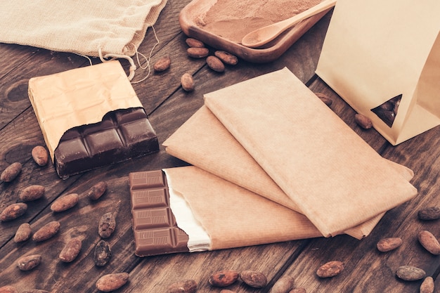 Chocolate bars and cocoa beans on wooden table